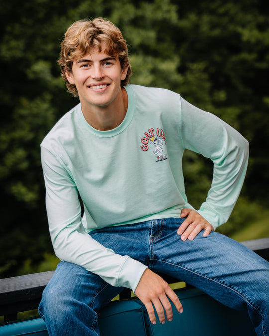 Guy sitting on a railing wearing a graphic long sleeve