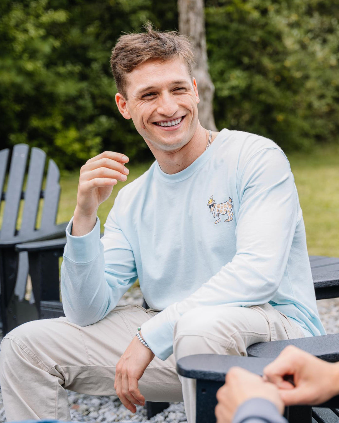 Guy sitting on a lawn chair wearing an ice blue long sleeve