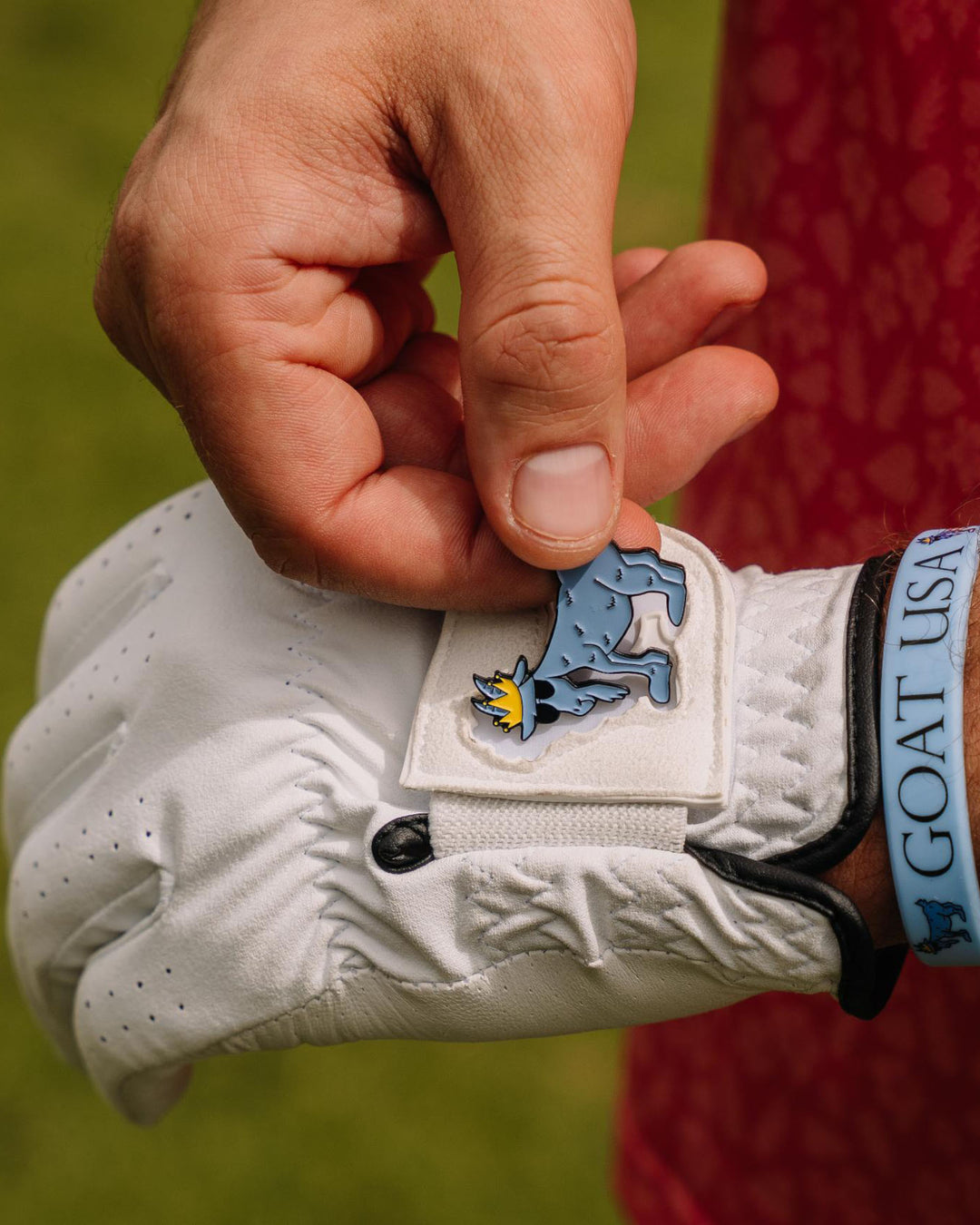 Guy taking ball marker off the golf glove