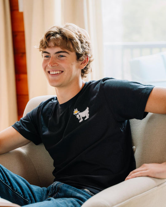 Guy sitting on couch wearing black WG T-Shirt#color_black