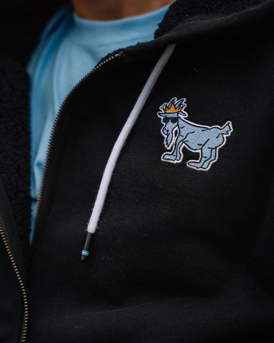 Close-up of logo on Black sherpa-lined full-zip sweatshirt#color_black