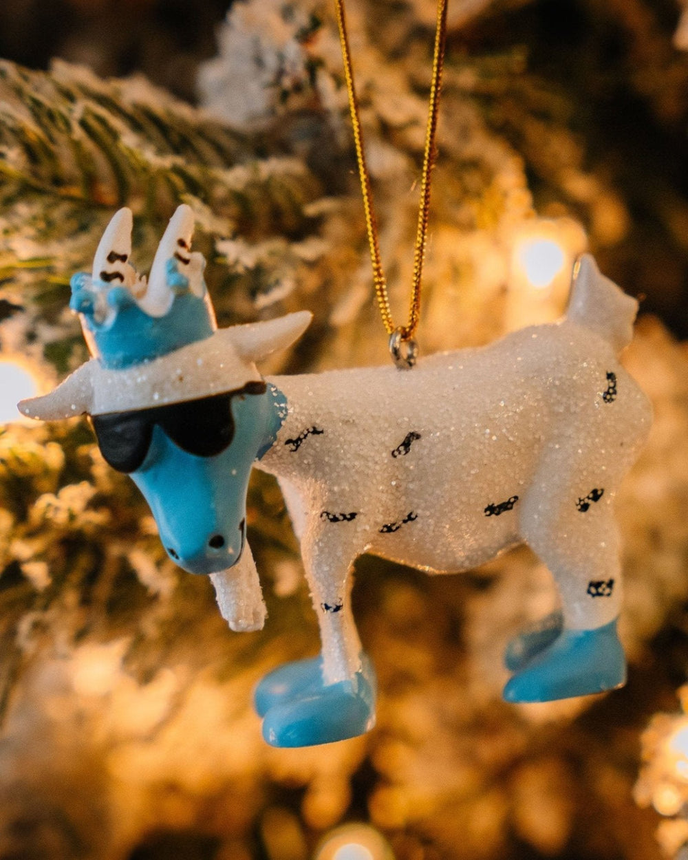 Yeti goat ornament hanging on a tree with ambient lighting