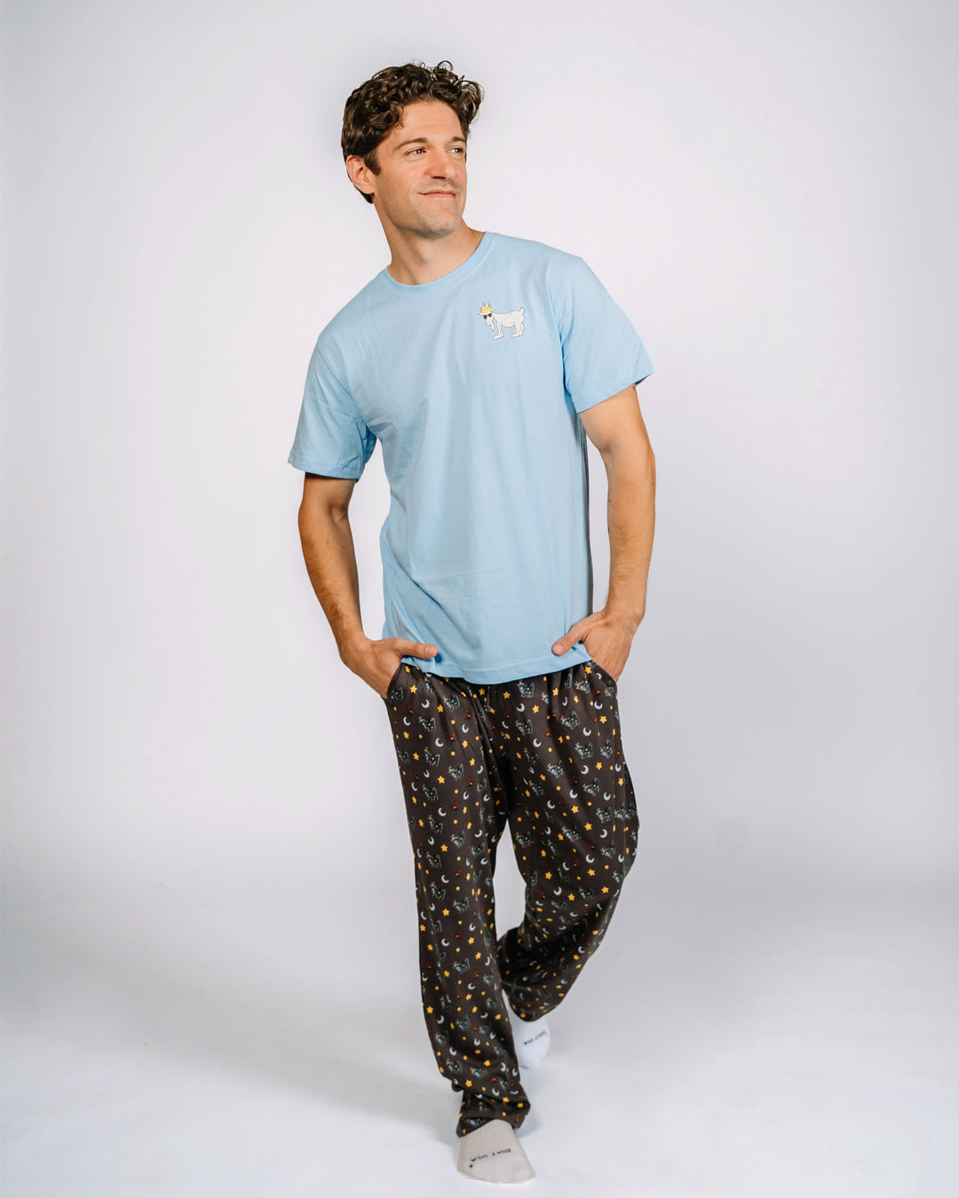 Male model wearing pajama pants with goats, teddy bears, stars and moons