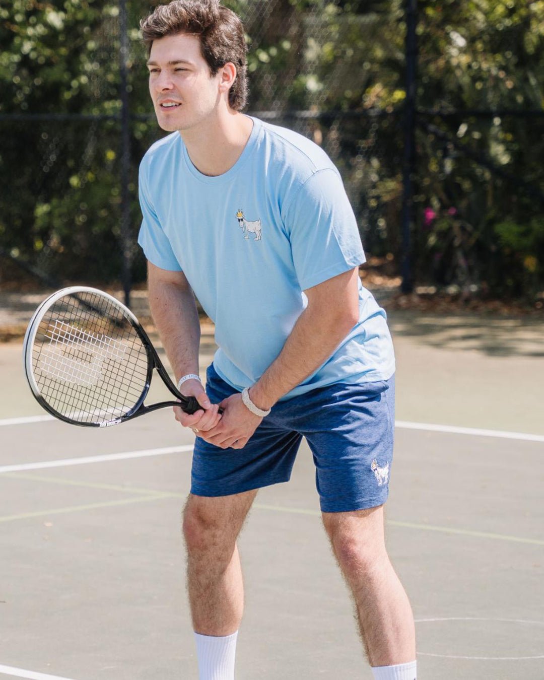 Guy playing tennis in a ready-to-go stance#color_navy
